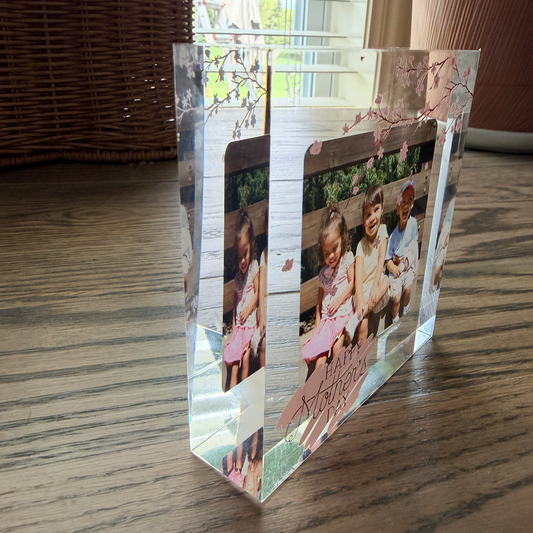 Side view of a custom acrylic photo block showing the depth of the clear acrylic and the layered effect of the photo printed on the back with the cherry blossom design on the front.